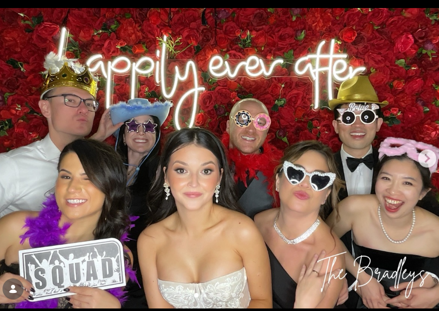 San Diego selfie booth flower wall backdrop — red rose wall with neon sign at a wedding